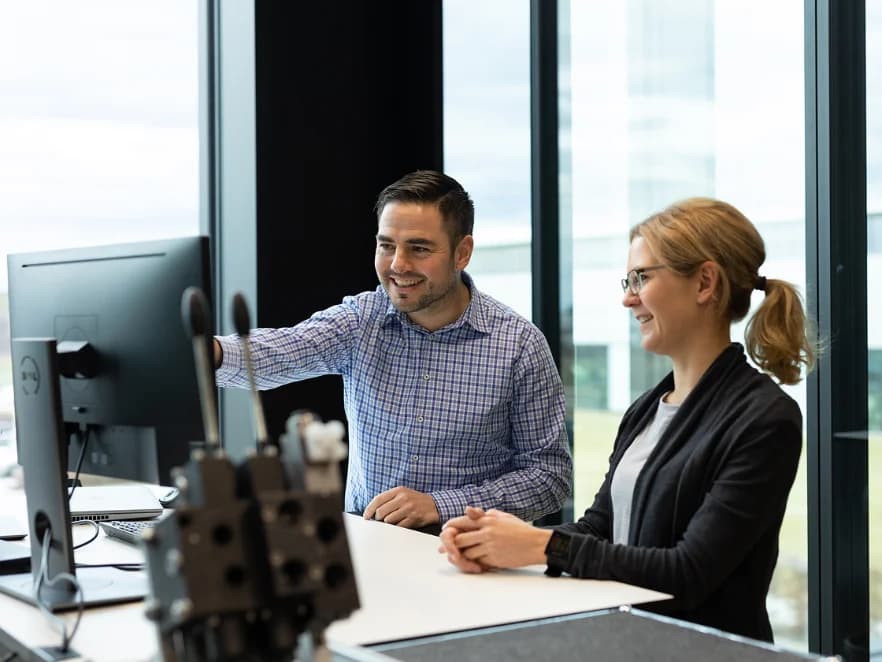 Photo of HAWE employees at work in the office, smiling